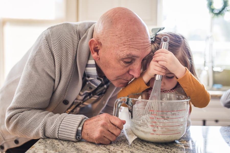 Man and child stirring a mixture in a measuring jug